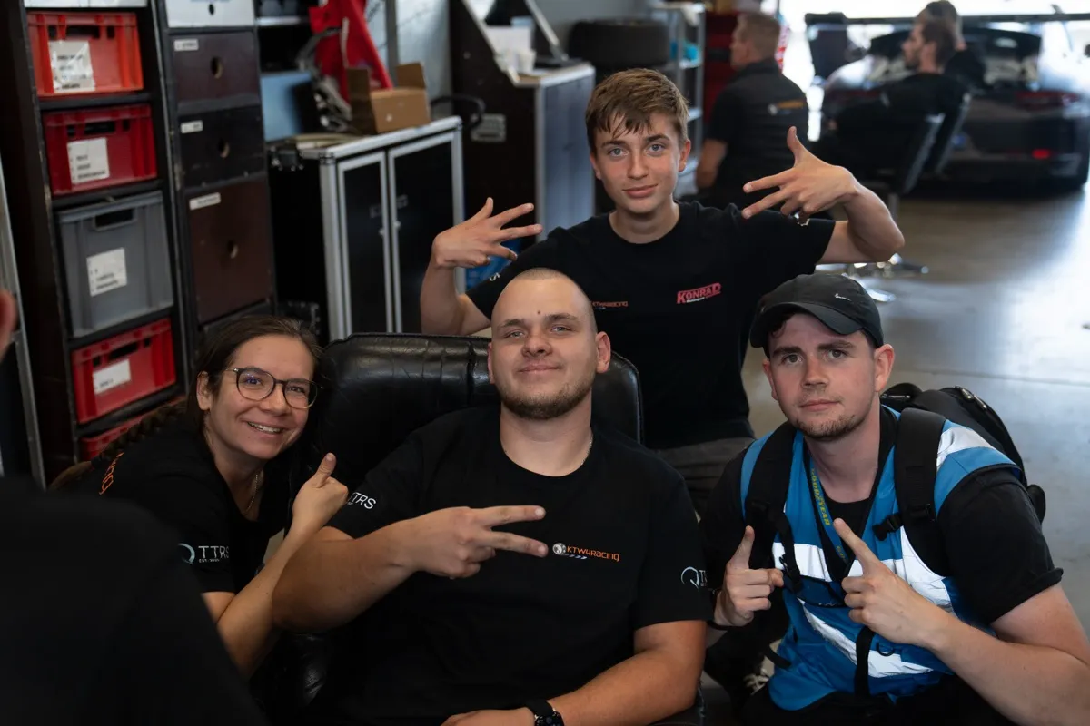 Junge Teammitglieder von KTW4Racing entspannt in der Garage, eine Person macht ein Peace-Zeichen