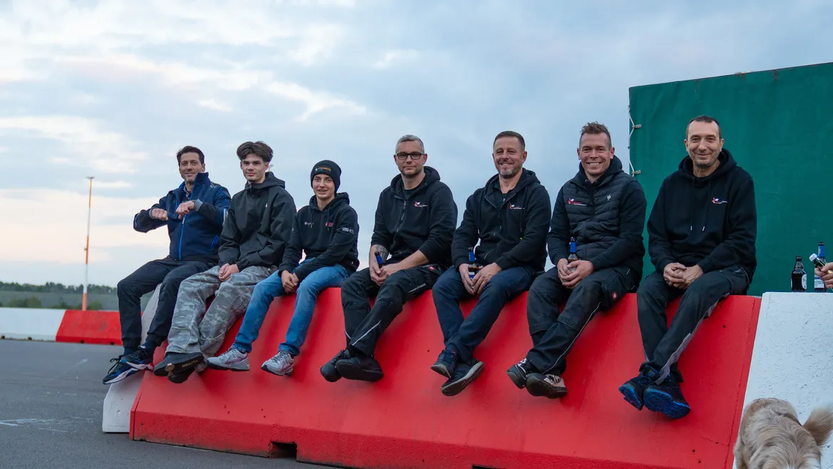 Das Team von KTW4Racing sitzt entspannt auf einer Streckenbegrenzung